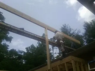 Carpenter setting a ridge beam over a new addition frame — Ice Dam Removal by Roofing Brothers in Dingmans Ferry
