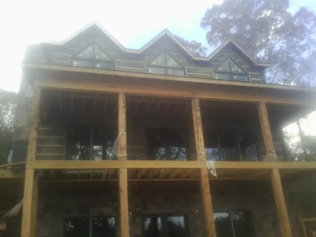Dormers and porch framing on a large log home under construction — Roof Coating work by our crew in Dingmans Ferry