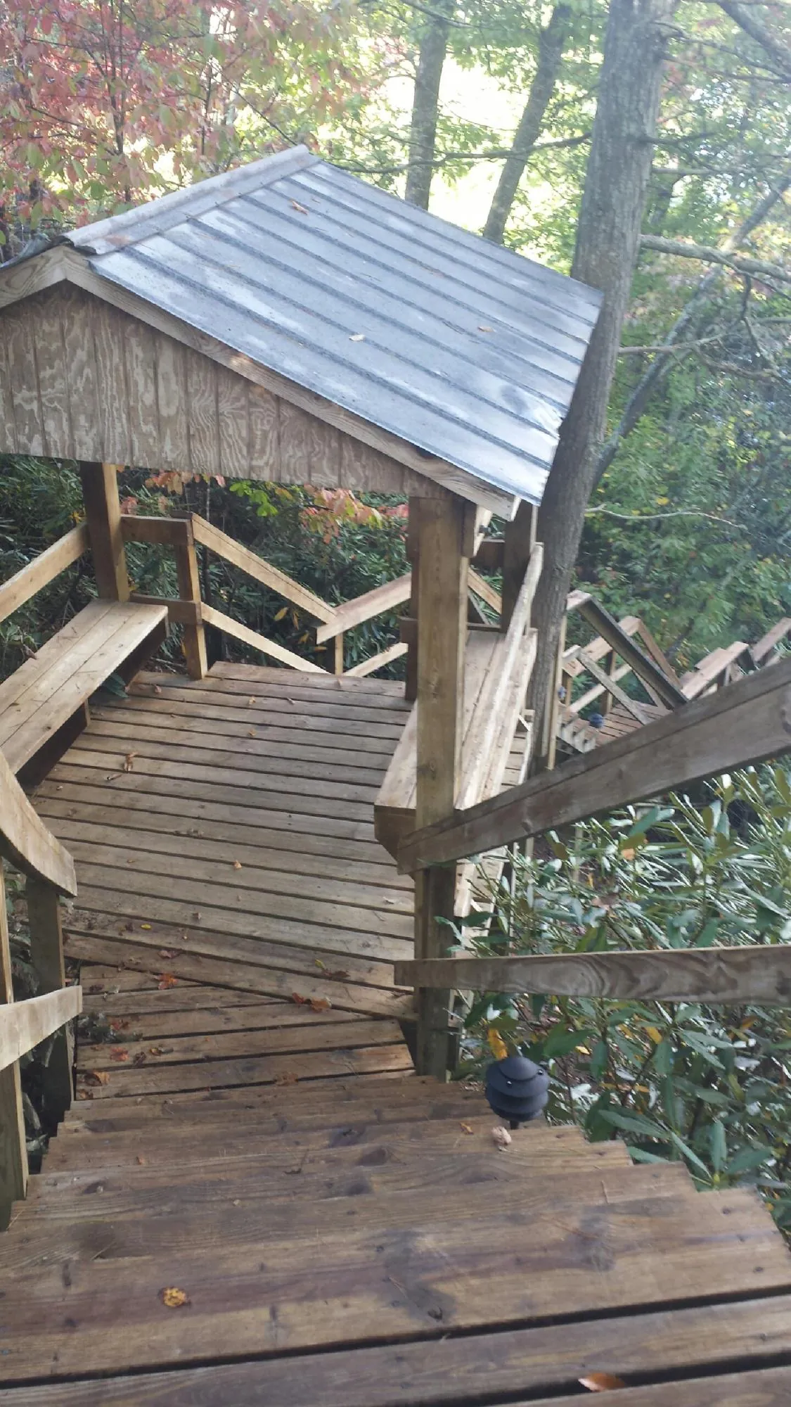 Metal roofed shelter over wooden steps on a wooded walkway — Skylight Repair & Installation work by our crew in Dingmans Ferry